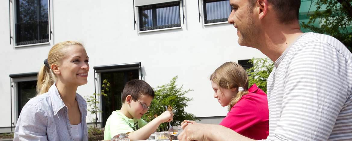 Familie beim Essen auf der Sonnenterrasse der Jugendherberge Köln-Riehl.