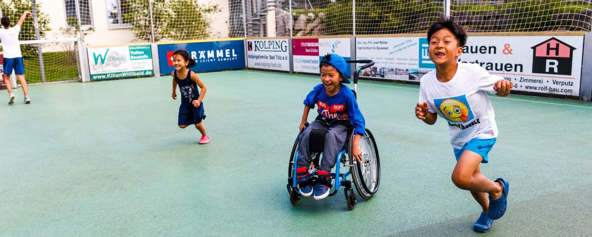 Mobilitätseingeschränkte Kinder spielen in der Speedsoccer Arena der Jugendherberge