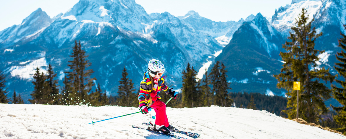 Ein Kind fährt die Piste in den Berchtesgadener Alpen hinab