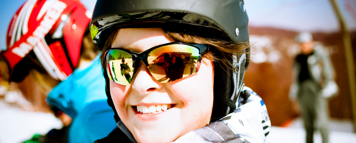 Lächelnde Schülerin auf der Piste während eines Skilagers