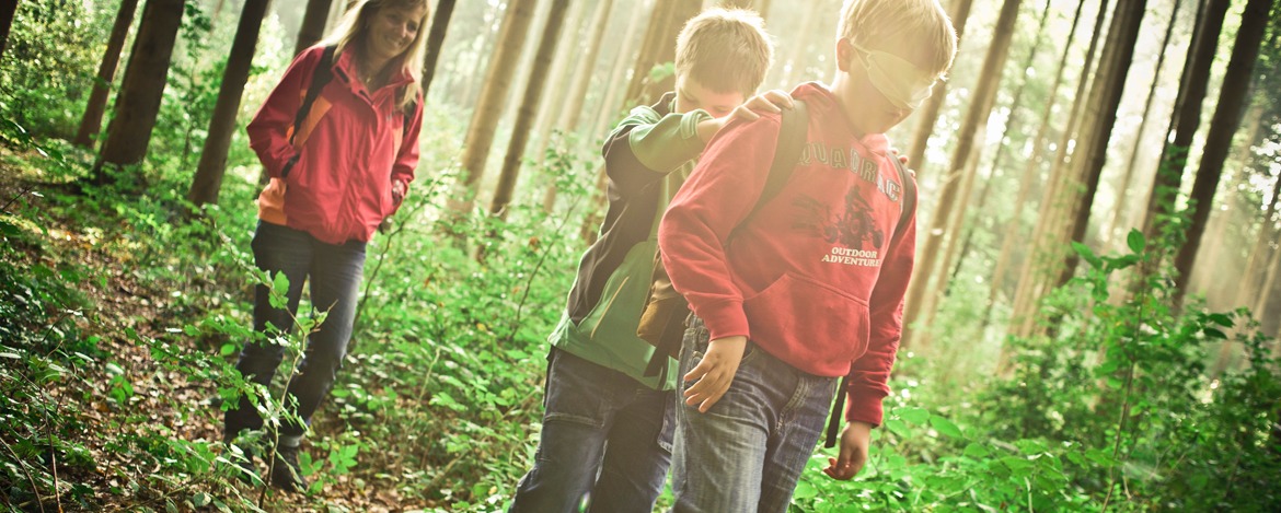 Jugendliche bei Team Building-Maßnahme im Wald während der Klassenfahrt