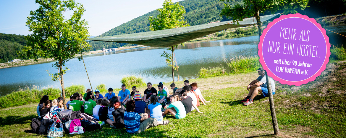 Jugendliche sitzen mit ihren Betreuern am Drachensee in Furth im Wald