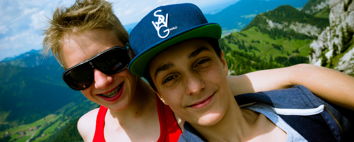 Glückliche Jungen nach Erklimmen eines Gipfels