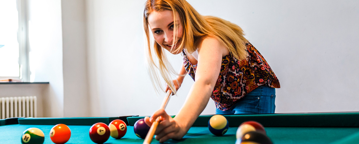 Junge Frau beim Billard spielen 