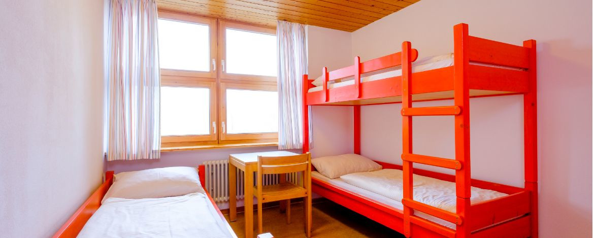 Zimmerbeispiel mit Stockbetten und einem Einzelbett in der Jugendherberge Pottenstein