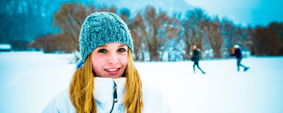 Lächelnde junge Frau inmitten einer Schneelandschaft